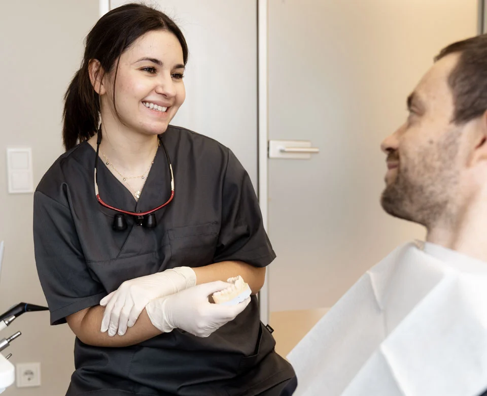 Beratung mit einem Patienten über einen Zahnersatz. 