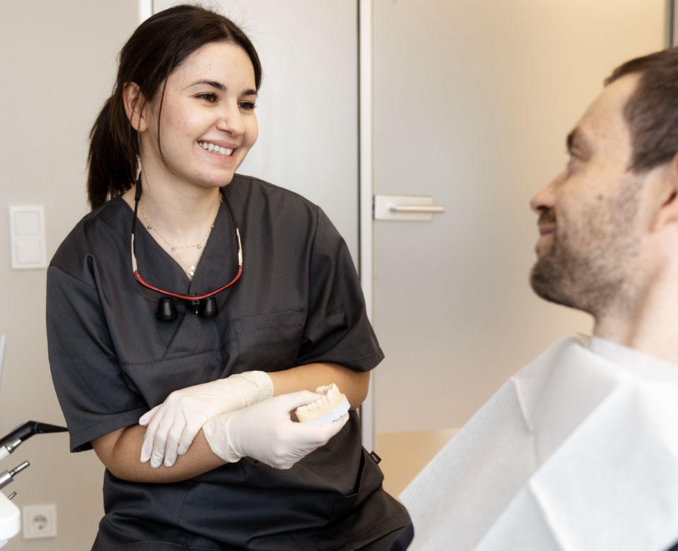 Beratung mit einem Patienten über einen Zahnersatz. 